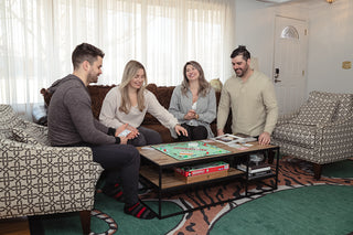 Group of friends enjoying a game of Monopoly in the main living area
