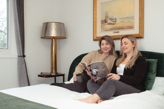 Relaxing at Cellar House Artful Dodger: Two women enjoying a peaceful moment, savouring a cup of coffee and reading a magazine.