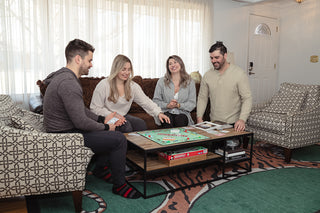 Group of friends enjoying a game of Monopoly in the main living area 