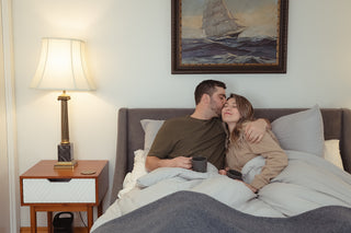 A couple enjoying a moment on the bed with a cup of coffee, embodying the tranquil ambiance of Cellar House.