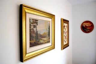 Gold-framed paintings showcasing natural landscapes. Experience artistic charm at Cellar House NOTL.